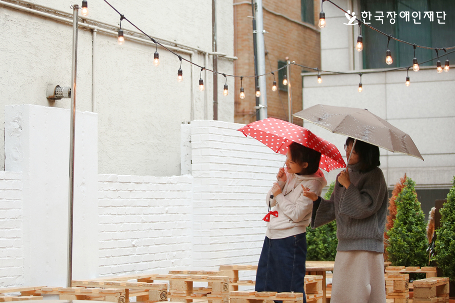 우산을 쓰고 있는 장혜영 장혜정 자매