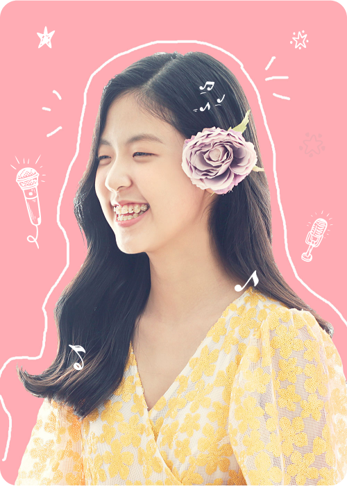 노란색 꽃모양 옷을 입고 왼쪽귀에 꽃을 꽂고 활짝 웃고있는 소정