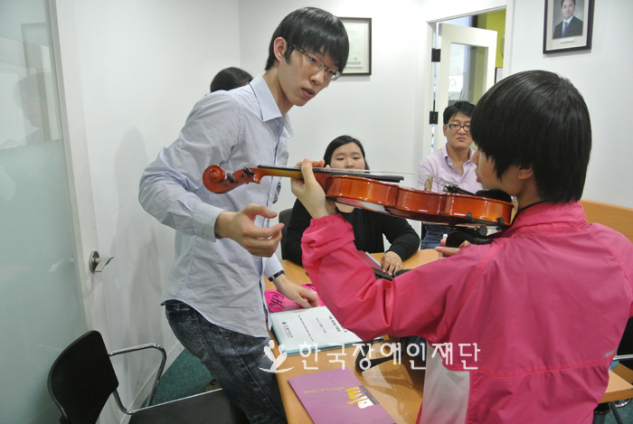 바이올린 사이즈를 확인하는 선생님과 학생 사진